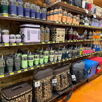 Outdoor Living SuppliesShelving unit with Yeti branded products including tumblers, coolers, and bags in a store setting.